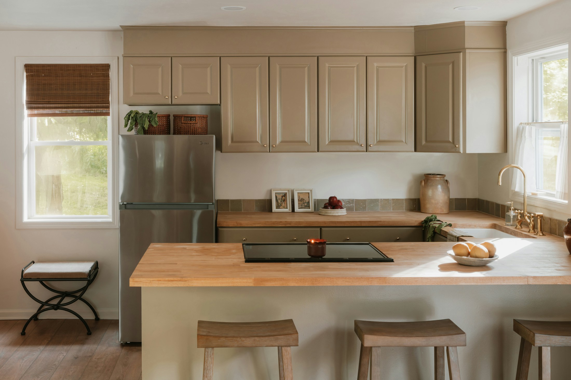 Cocina moderna con isla, mobiliario de madera clara y luz natural
